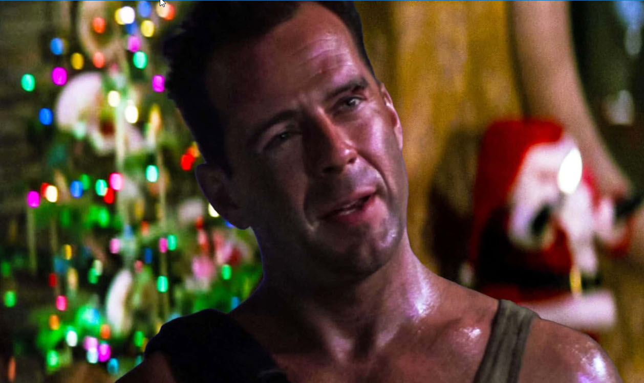John McClane in front of a Christmas tree.
