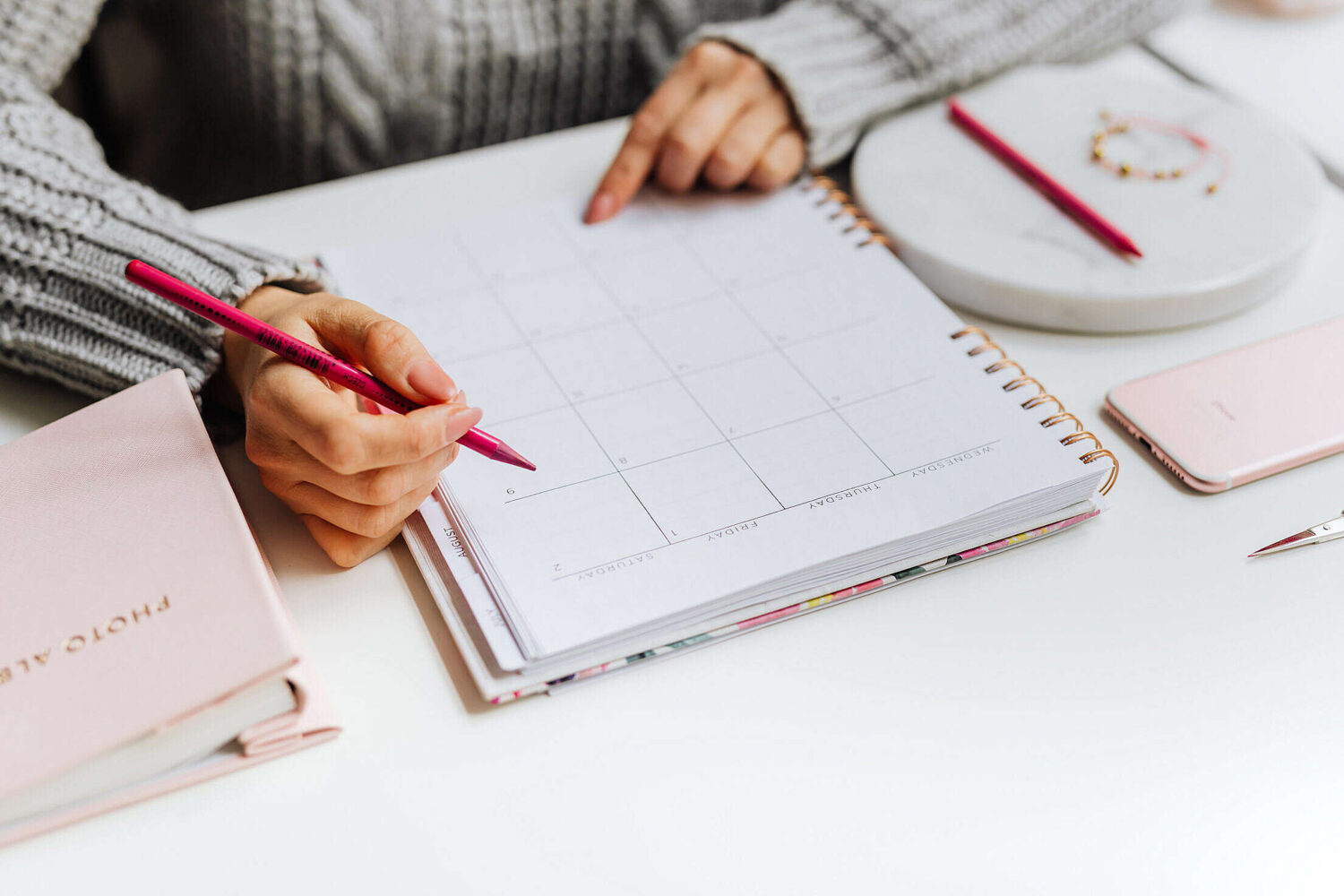 Person writing simple and sustainable goals in a notebook.