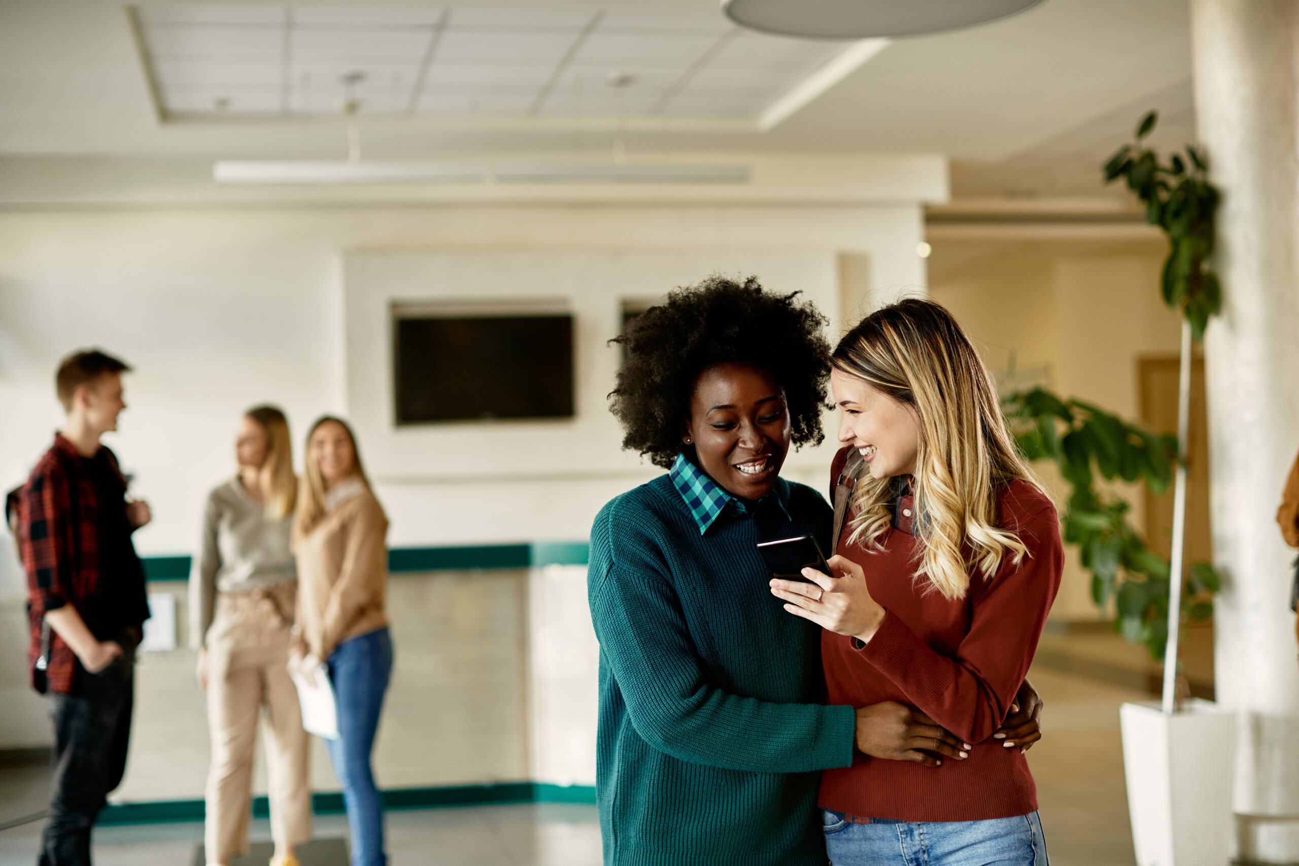 Colleagues laughing and connecting in a lounge, sharing career stories.